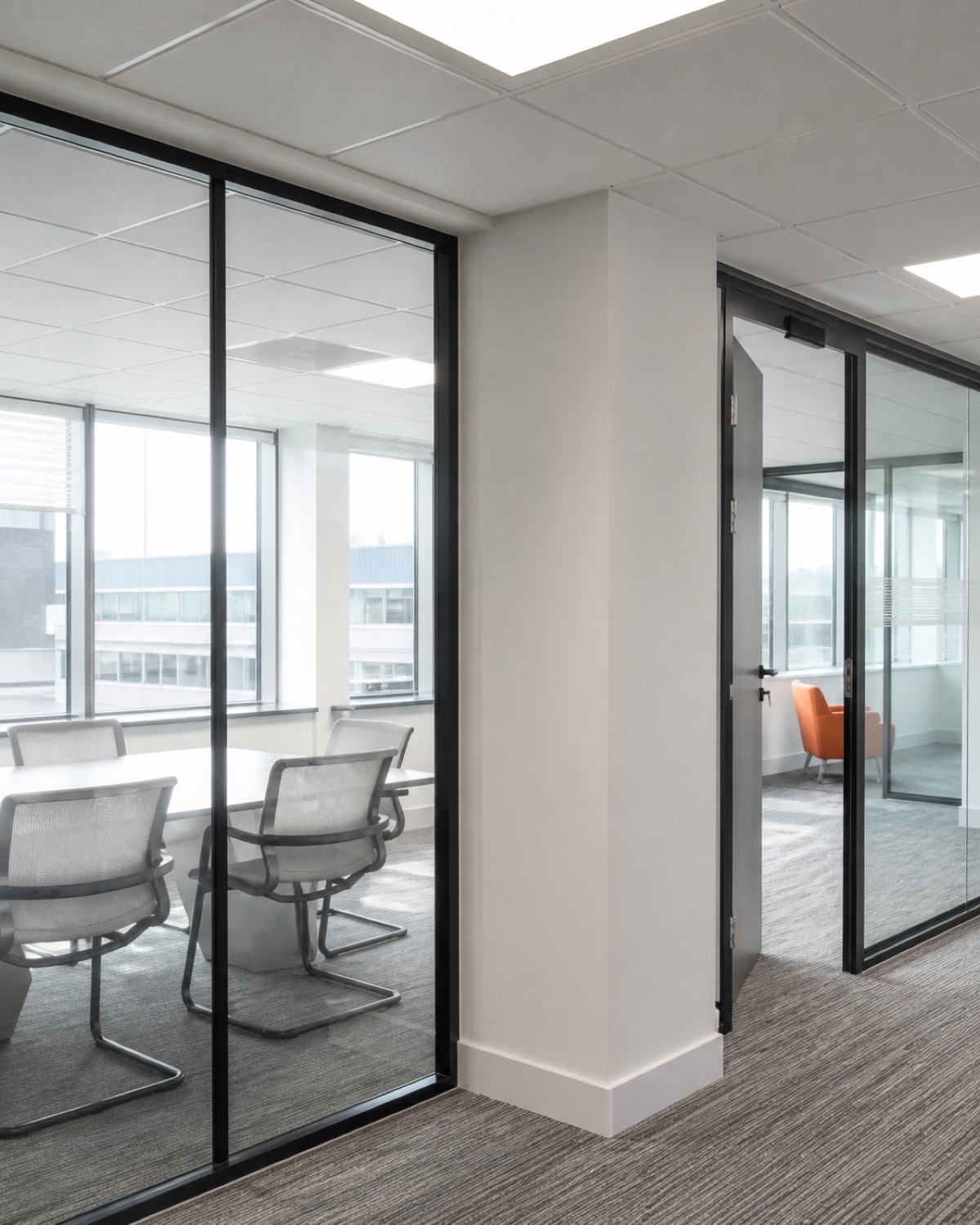 Completed glazed office partitions meeting a suspended ceiling